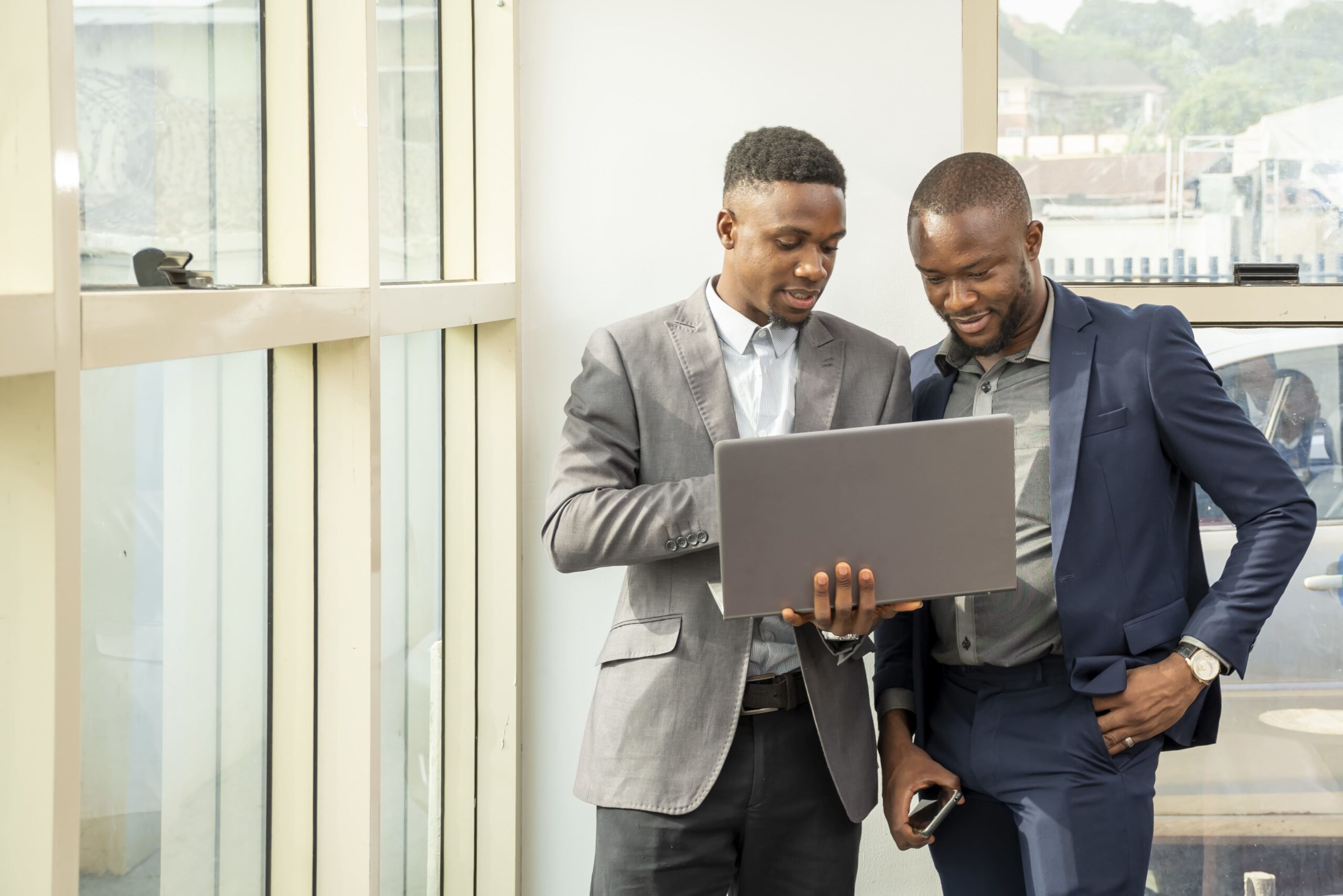 https://legalhubpartnership.com/wp-content/uploads/2023/07/young-businessmen-standing-together-holding-laptop-discussing-business-min-scaled.jpg